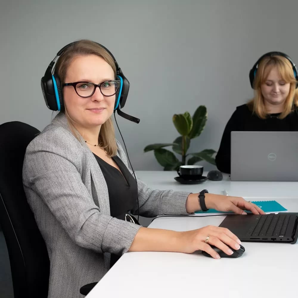 To kvinner med hodetelefoner i Orbitvus kundesupportkontor